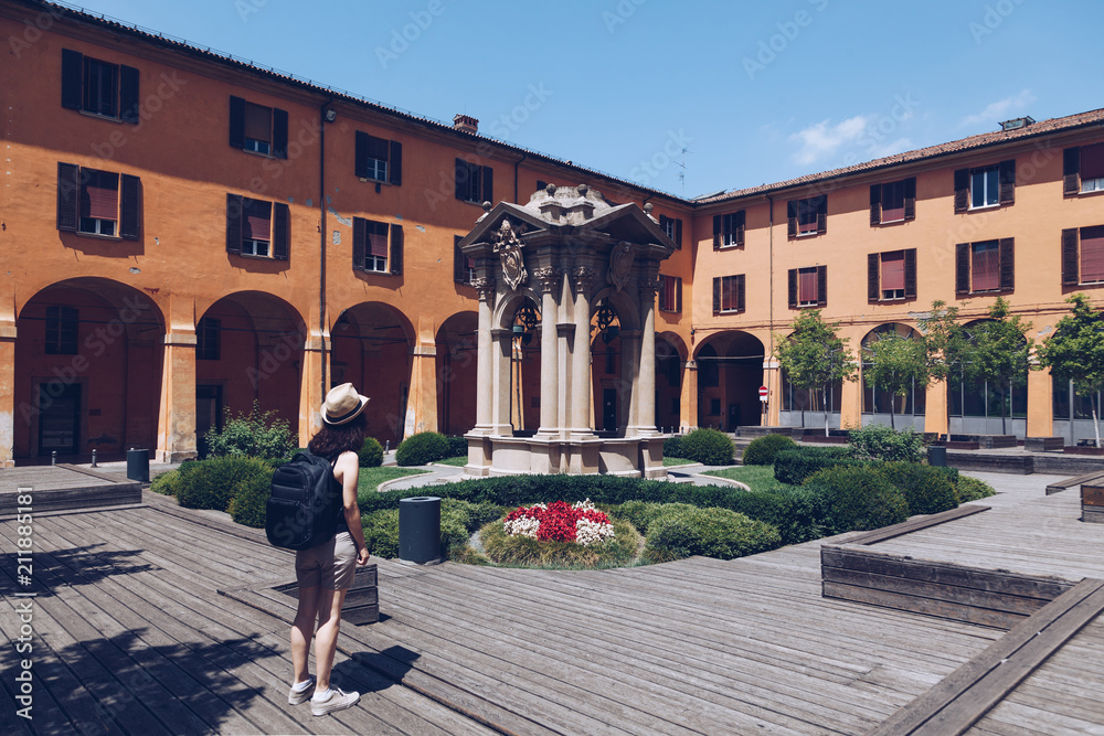 tourist girl looking at old buildings in bologna - visiting the city of culture - travel destination - italy - bella italia