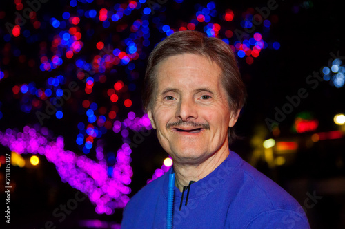 Happy Downs Syndrome Man in Front of Christmas Lights photo