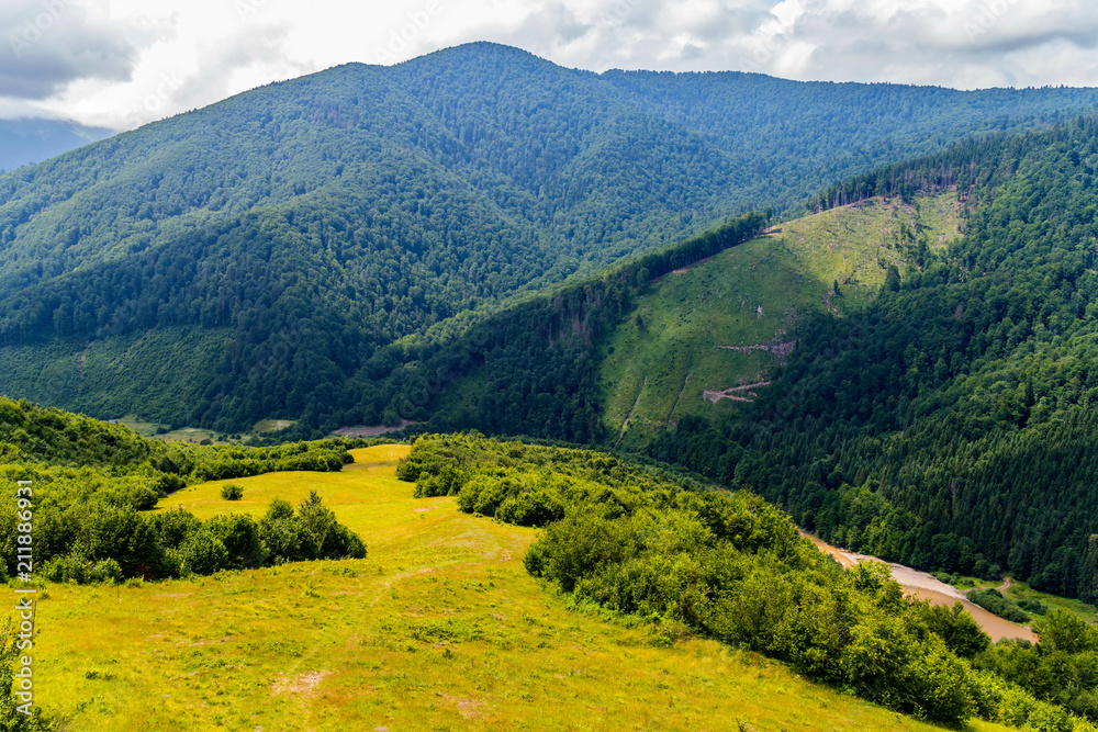 beautiful landscape on the Carpathian mountains with a river in the valley over which the shadows of clouds