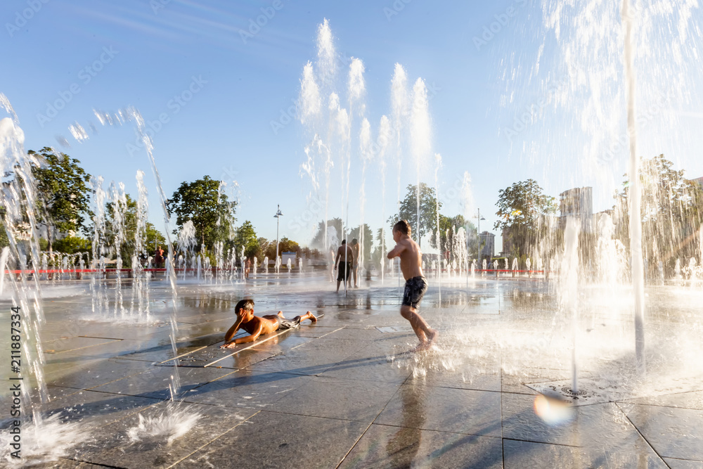 Unidentified Kids playing in the fountain in city park