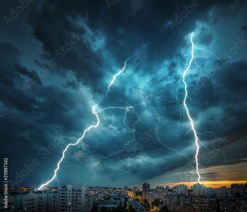 Lightning thunderstorm flash over the night city. photo