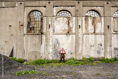 Unidentified man holds a red traffic triangle warning sign