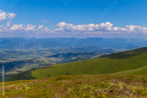 The green mountains beyond the horizon under the blue cloudy sky