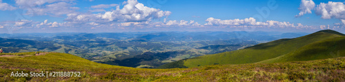 A majestic panorama of green mountain peaks stretching to the horizon line
