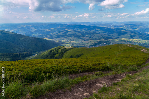 Mountain road leading to the descent of a high hill against the blue sky