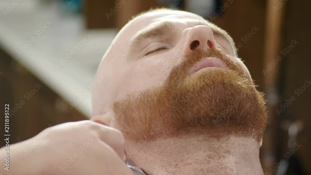 Shaving of beard. Barber cutting men's face hair with beard trimmer at barbershop. 4K Shaving of beard. Barber cutting men's face hair with beard trimmer at barbershop. 4K