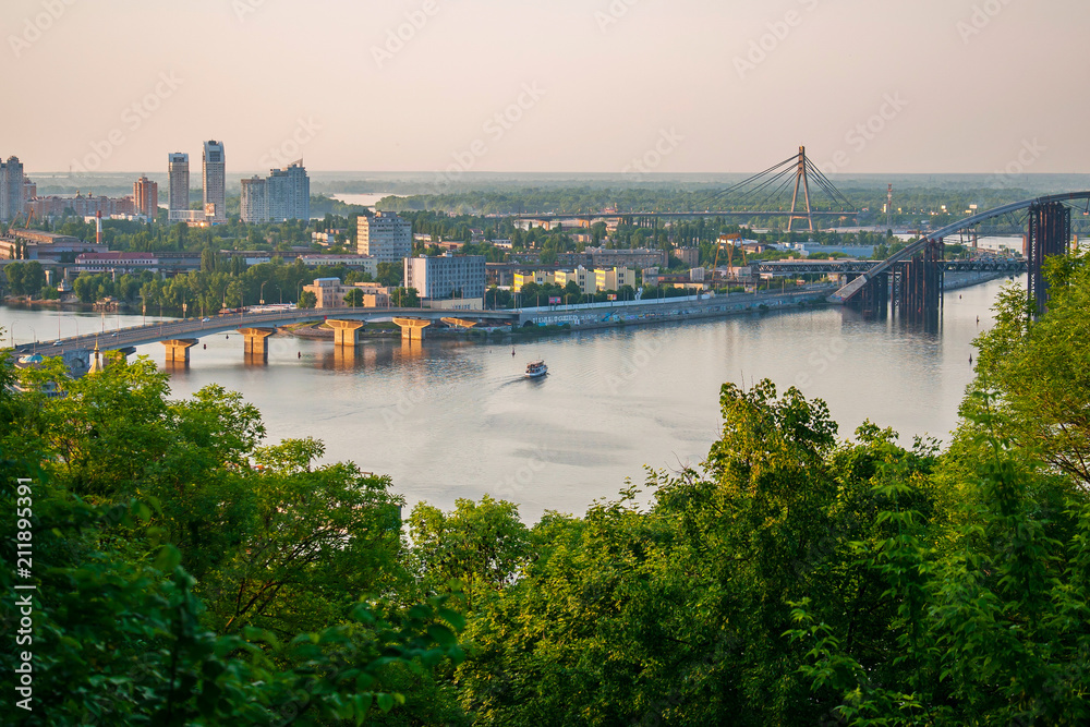 A panorama of town houses with bridges linking the shores of a winding river. Kyiv, Ukraine