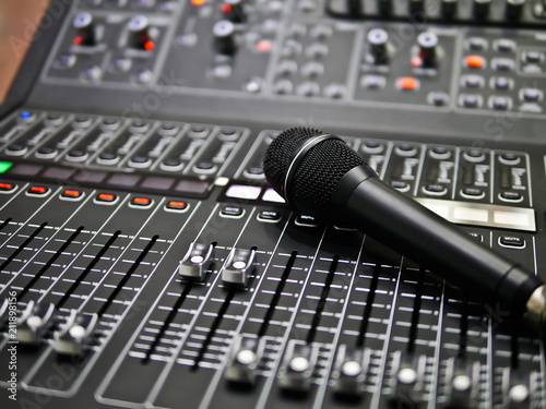 Картината върху платно microphone rests on an audio mixer controller in the control room, Sound mixer c
