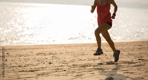 young fitness female runner running at beach