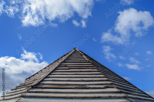 Wooden old rusty roof pattern with blue cloudy sky