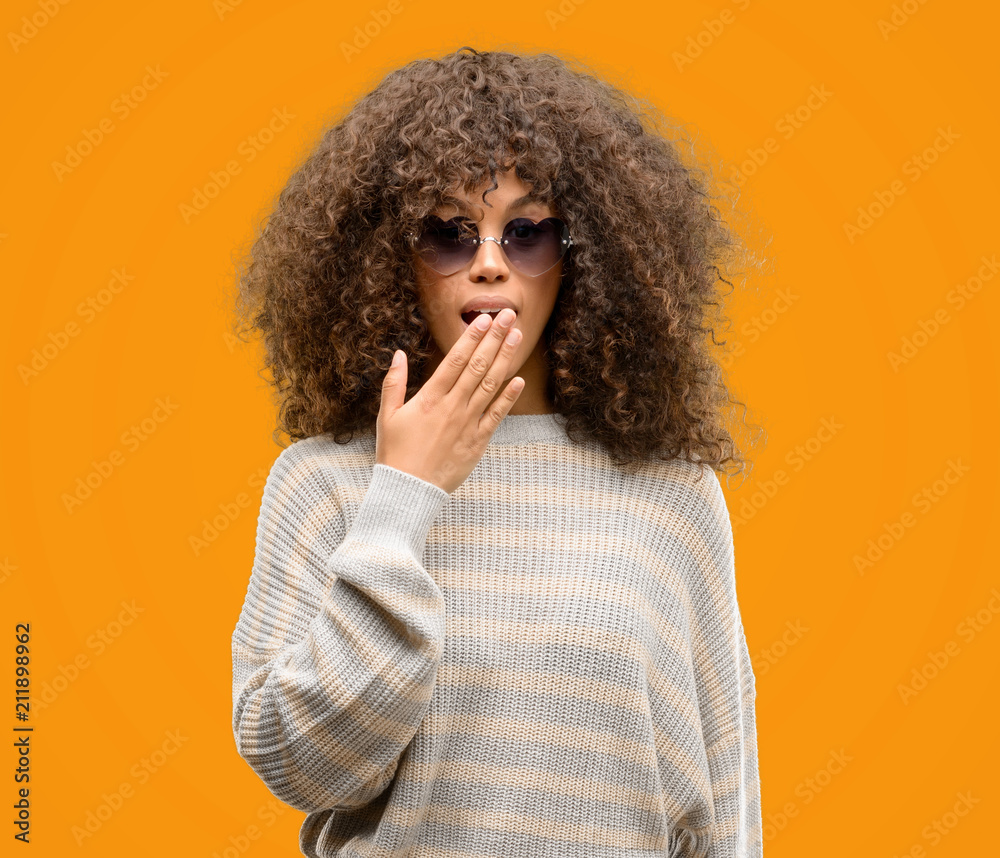 African american woman wearing a stripes sweater cover mouth with hand shocked with shame for mistake, expression of fear, scared in silence, secret concept African american woman wearing a stripes sweater cover mouth with hand shocked with shame for mistake, expression of fear, scared in silence, secret concept