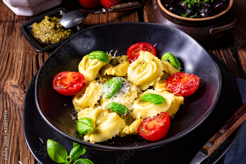 rustic spinach tortellini with cheese and cocktail cocktail tomatoes photo