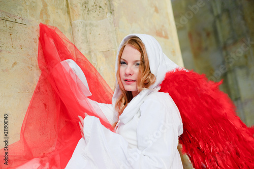 young blonde in a white canopy and red wings photo