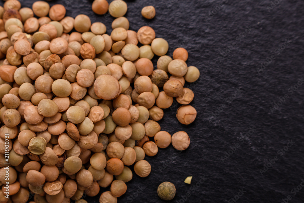 raw lentils on a dark stone background