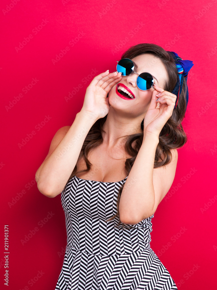 The girl in a red dress on a red background in the studio The girl in a red dress on a red background in the studio