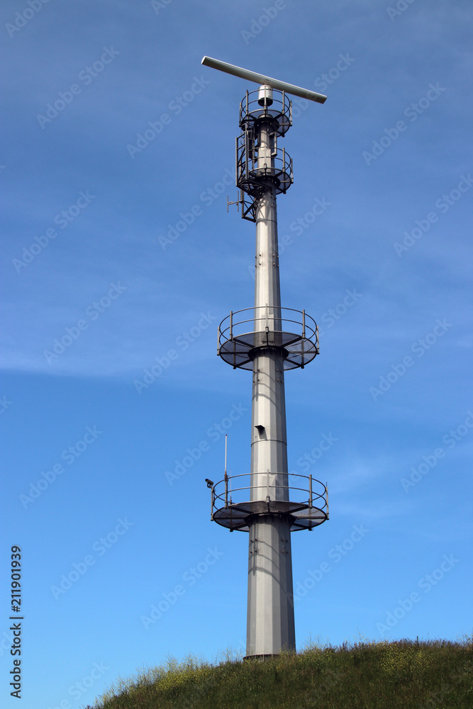 Radar antenna on tall mast at the port of rotterdam to guide ships. Radar antenna on tall mast at the port of rotterdam to guide ships.