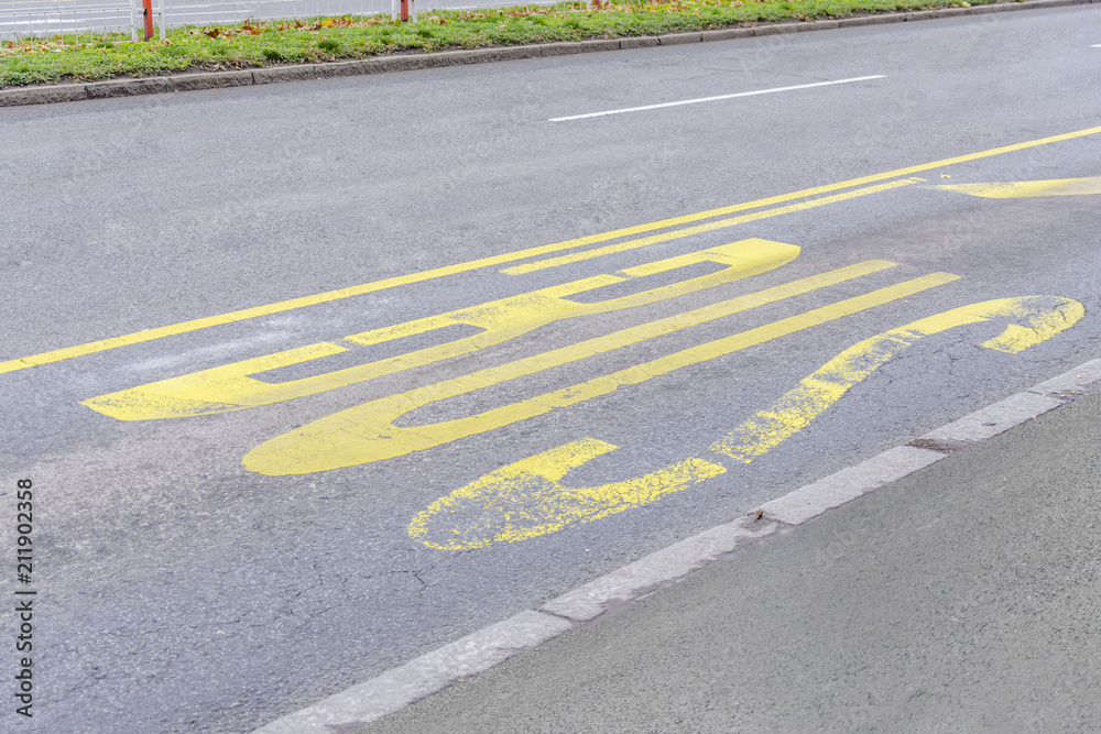 Obraz premium Yellow bus stop painted pattern on asphalt road in the city