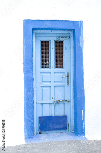 Old blue wooden church door on white wall © isabela66