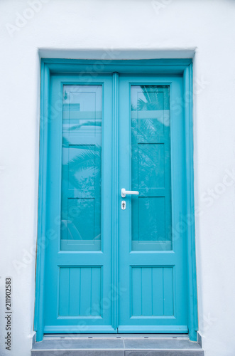 New blue wooden door on white wall  Santorini