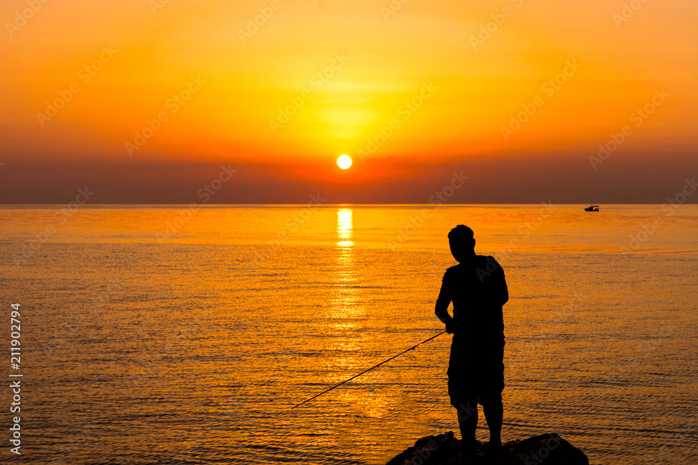 Silhouette of a fisherman by the sea