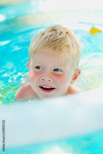 Portrait of baby boy enjoying swimming in inflatable pool