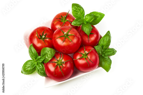 Fresh juicy tomatoes with basil leaf, isolated on white background. Close-up.