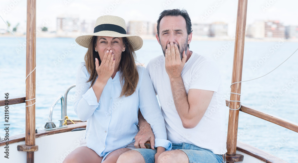 Middle age couple traveling on sailboat cover mouth with hand shocked with shame for mistake, expression of fear, scared in silence, secret concept