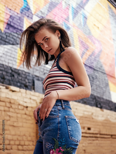 Female fashion concept. Outdoor waist up portrait of young beautiful woman posing on old street. Model wearing stylish clothes, looking at camera. Sunny day. City lifestyle. Copy, empty space for text © Elena Kharichkina