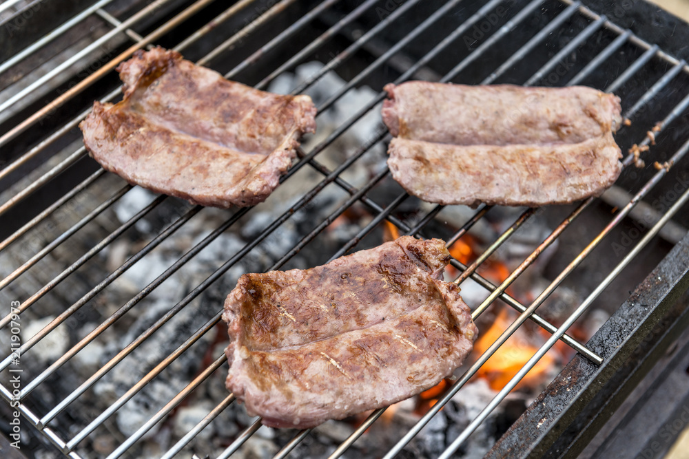 Sausages cook on the grill