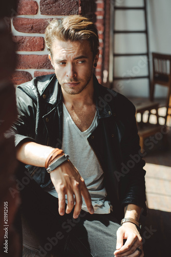 Stylish handsome caucasian man on a brick wall background