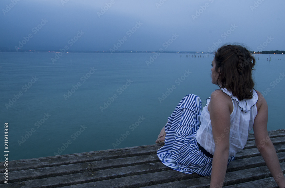 Girl looking at the sea from a pier