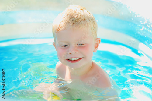 Portrait of baby boy enjoying swimming in inflatable pool