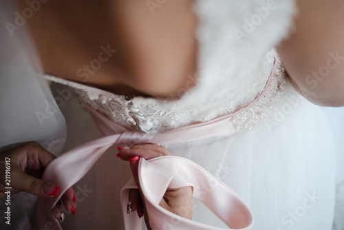 bride in a wedding dress, bride's fees, dressing up a wedding dress, back of the bride, morning of the bride, wedding day photo