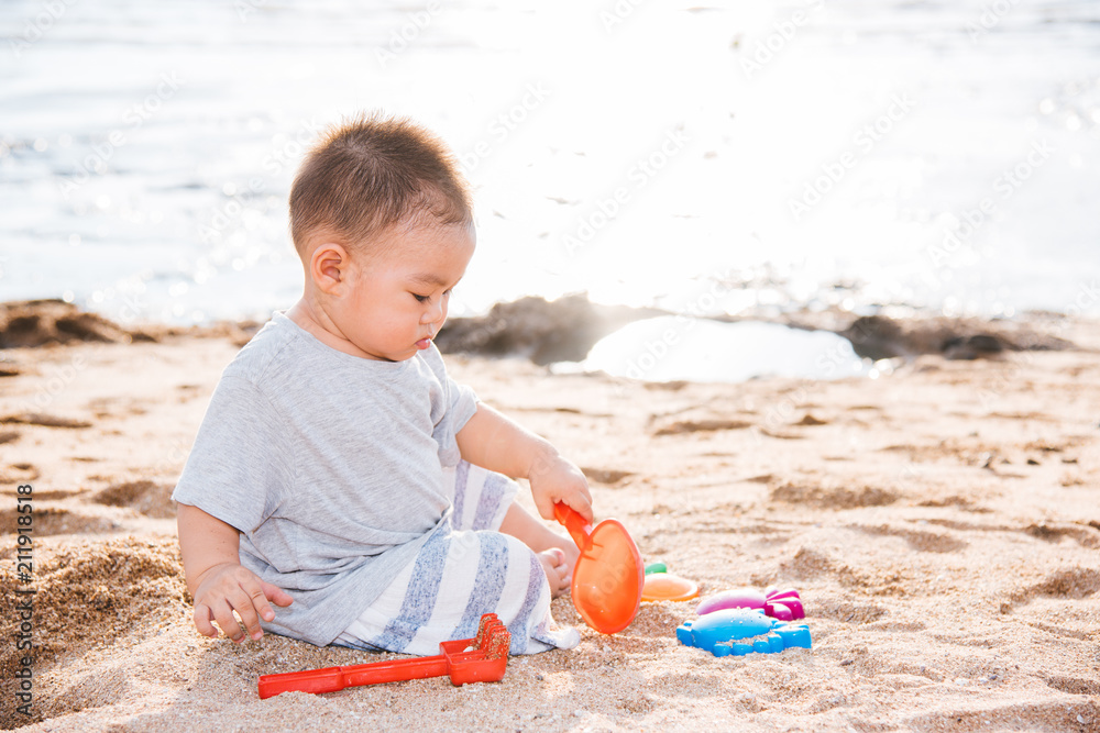 Baby boy playing sand on sea beach Baby boy playing sand on sea beach
