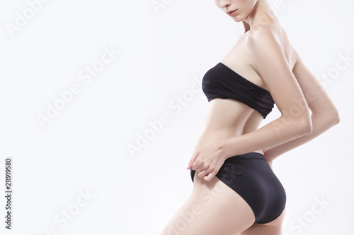 Body of a white Caucasian girl with perfect skin. Buttocks of a young slender model in black lingerie.