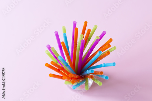 Colorful straws on a pink background