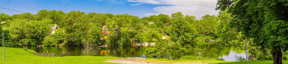 Panorama of a typical Ukrainian village in the spring. Village on the shore of the pond, Oposhnya, Ukraine Panorama of a typical Ukrainian village in the spring. Village on the shore of the pond, Oposhnya, Ukraine