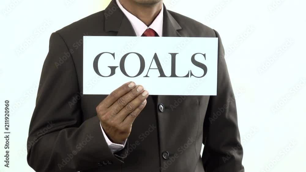 Businessman holding white card with Goals sign Businessman holding white card with Goals sign