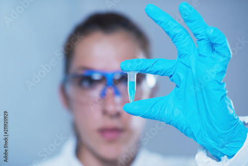 Young female scientist holding micro test tube