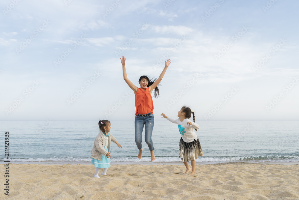 Happy mother with two daughters playing on the beach Happy mother with two daughters playing on the beach