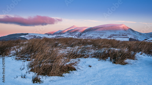 Winter Sunrise on Skiddaw touching the tops of the mountain on a cold snowy morning photo