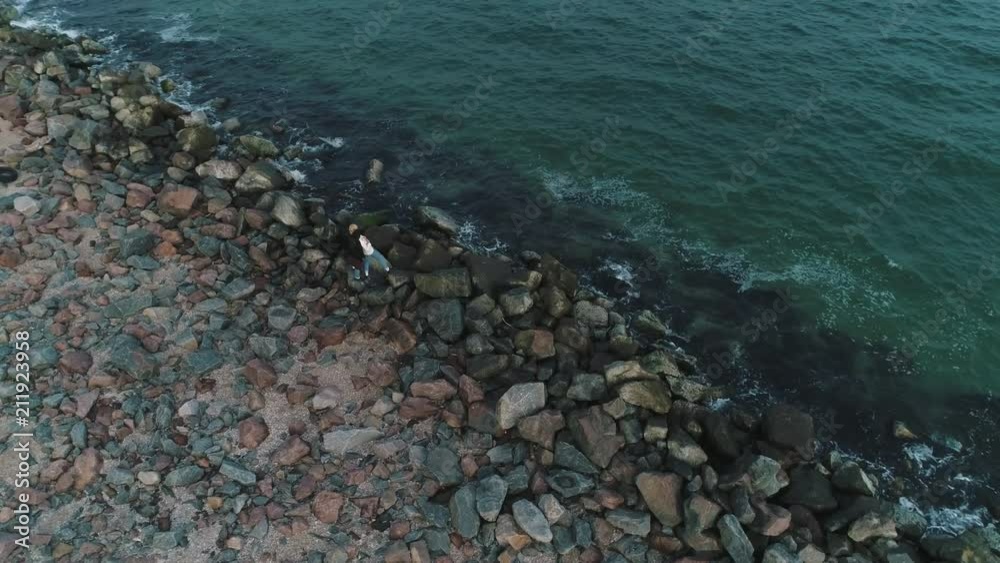 aerial view of couple on a stony beach near the sea. aerial view of couple on a stony beach near the sea.