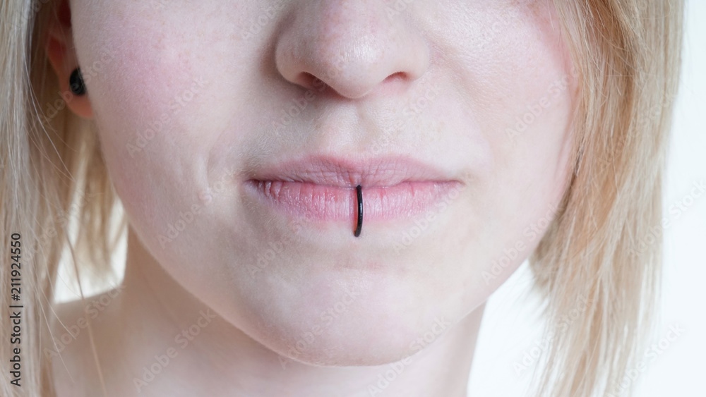 Stockfoto pierced female lips with vertical labret piercing or lip ring on  middle lower lip | Adobe Stock