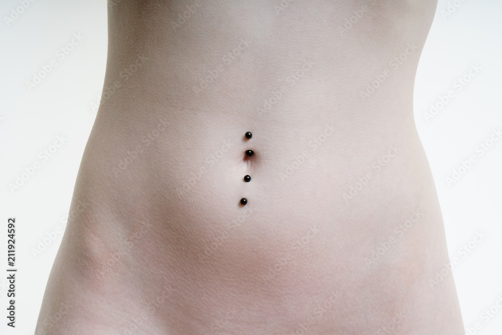 female stomach belly button or navel pierced with double barbell piercing  Stock Photo | Adobe Stock