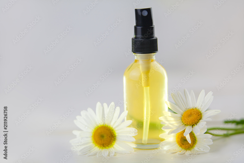 Essence of flowers on table in beautiful glass bottle Essence of flowers on table in beautiful glass bottle