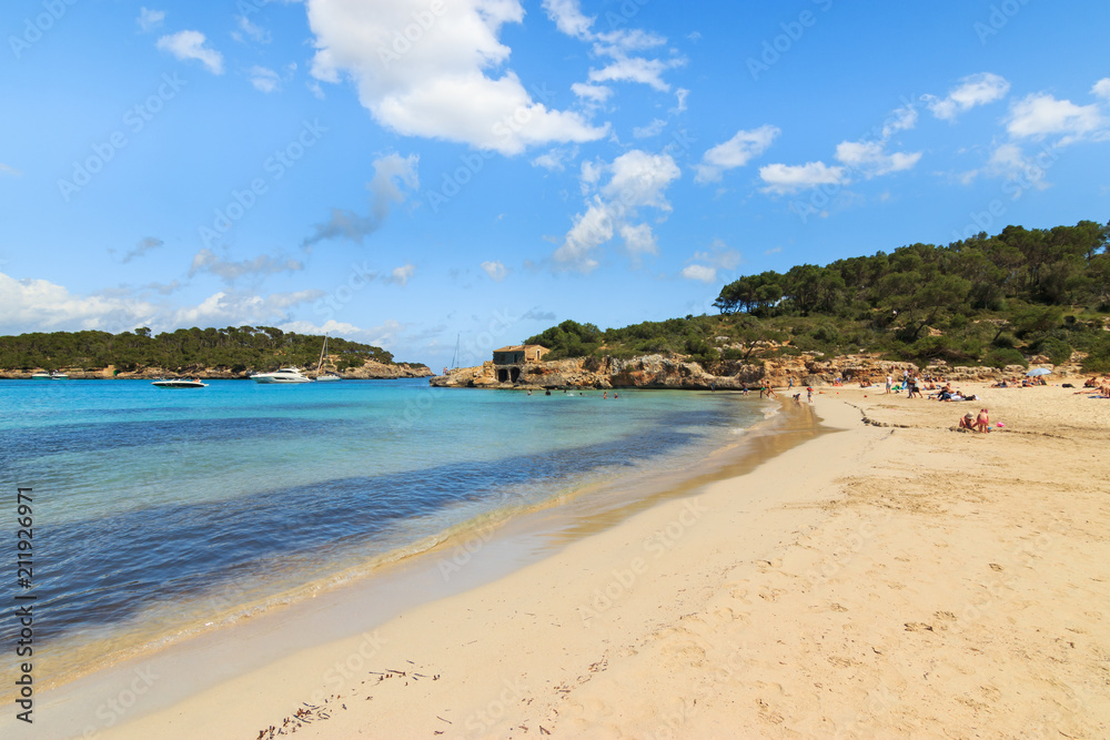 Sandy beach and clear blue turquoise waters in a island of Mediterranean Sea. Holidays concept in Cala Mondrago natural park. Majorca in Balearic Islands Spain.