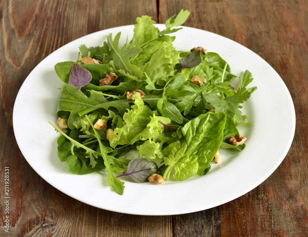 Fresh green salad with spinach, arugula, lettuce, herbs and nuts Fresh green salad with spinach, arugula, lettuce, herbs and nuts