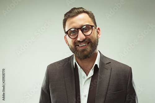 The happy business man standing and smiling against pastel background.