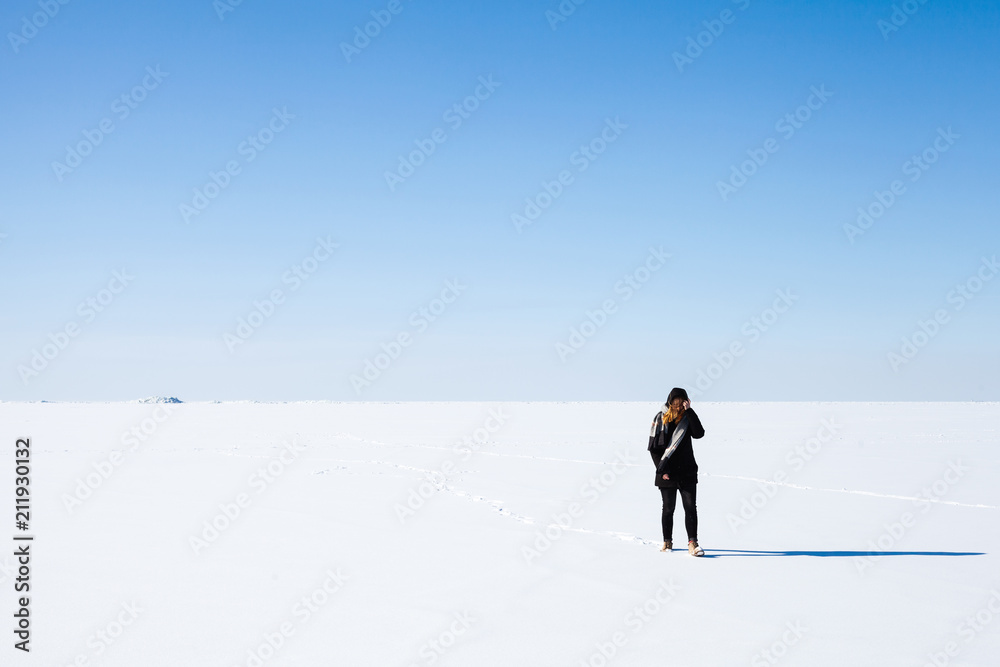 Teenage girl in black walks on frozen Sea