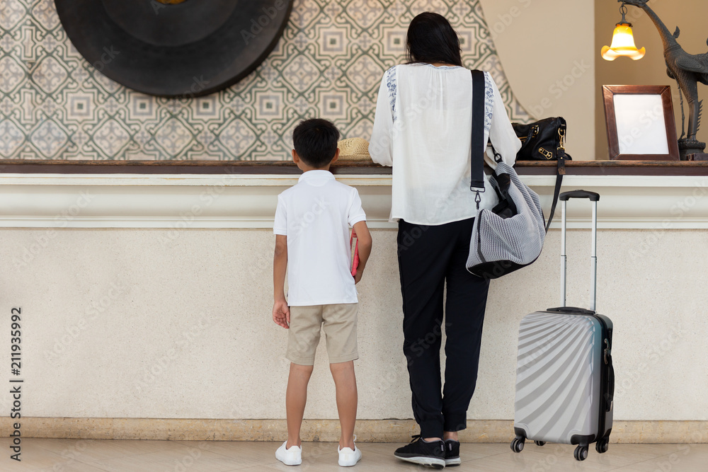 Fototapeta premium Family value Mother and Son checking in at hotel with suitcase